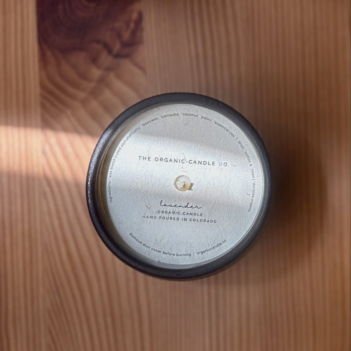 Organic candle with label on a wooden surface, featuring 'The Organic Candle Co.'