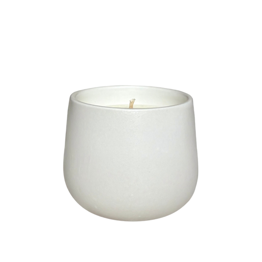 A white ceramic organic candle centered on a solid white background.