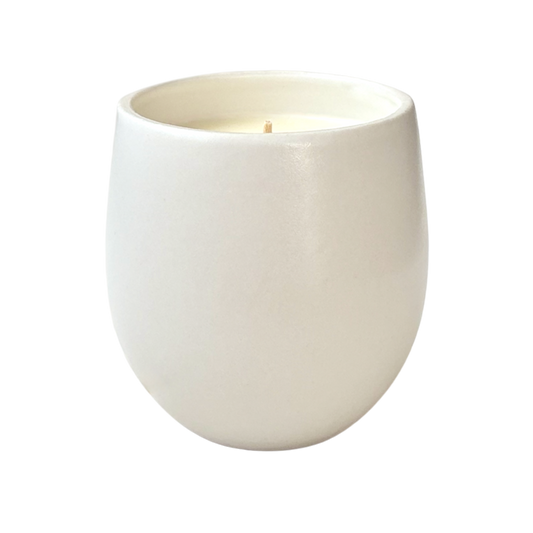 A white organic ceramic candle shown against a neutral background.