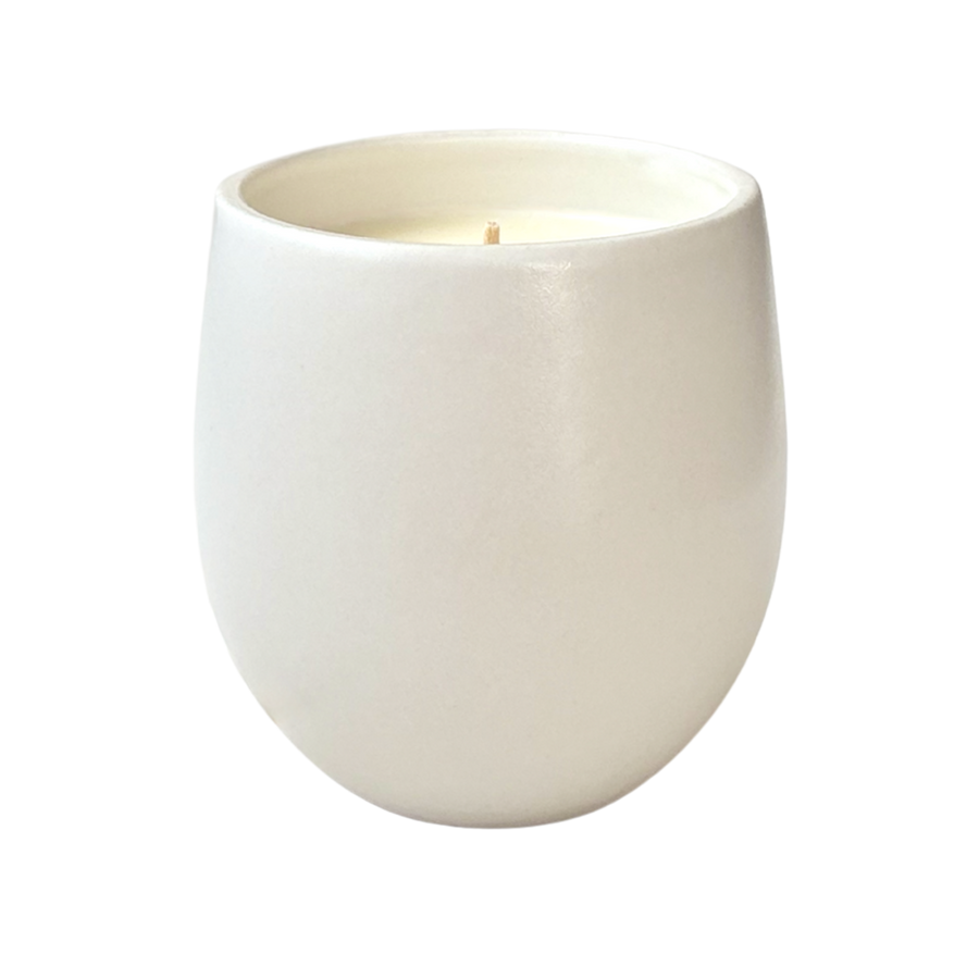 A white organic ceramic candle shown against a neutral background.