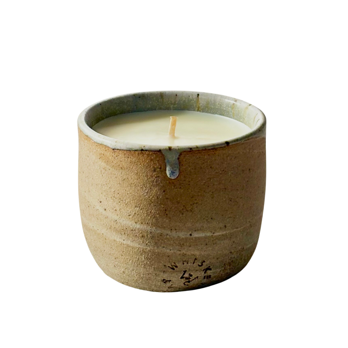 An organic candle in a handmade, speckled beige cup with a small blue-gray accent at the rim, shown on a plain white background.