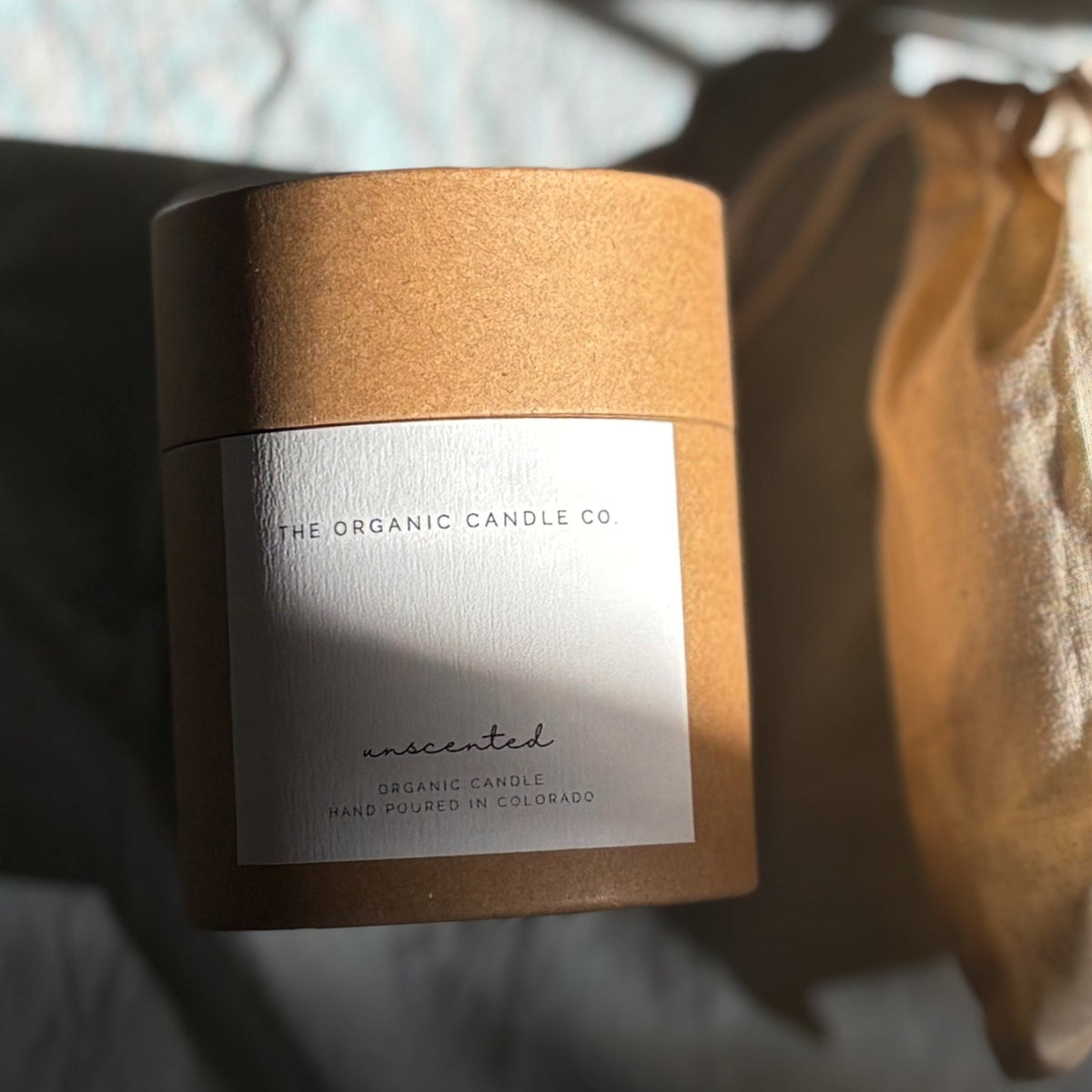 Candle packaging with 'The Organic Candle Co.' label on a blurred background